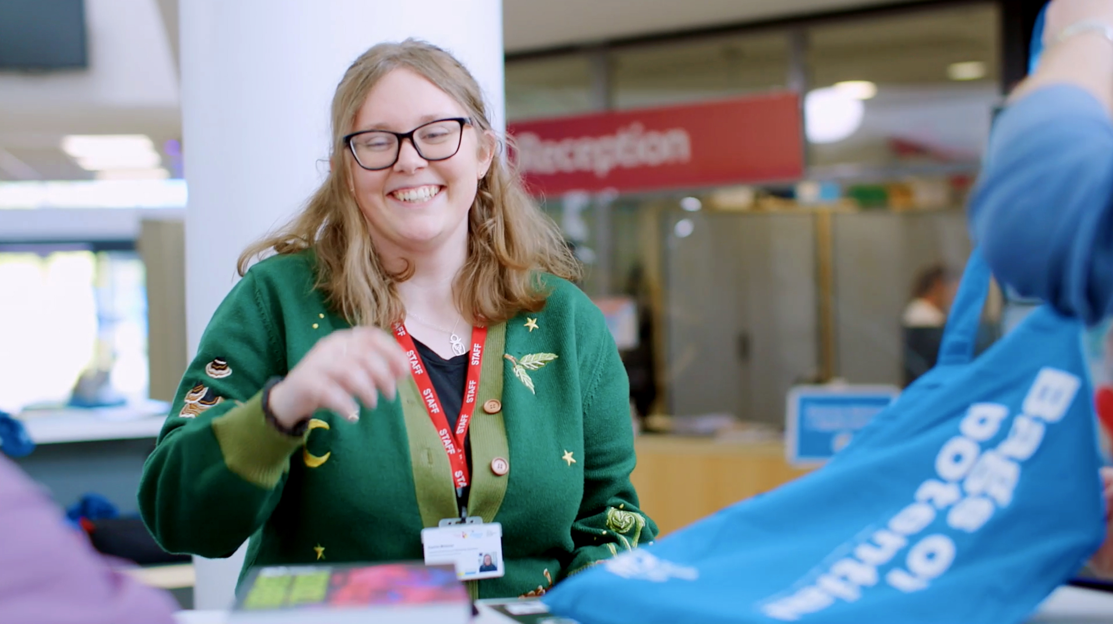 COPC staff smiling at welcome desk during an open event